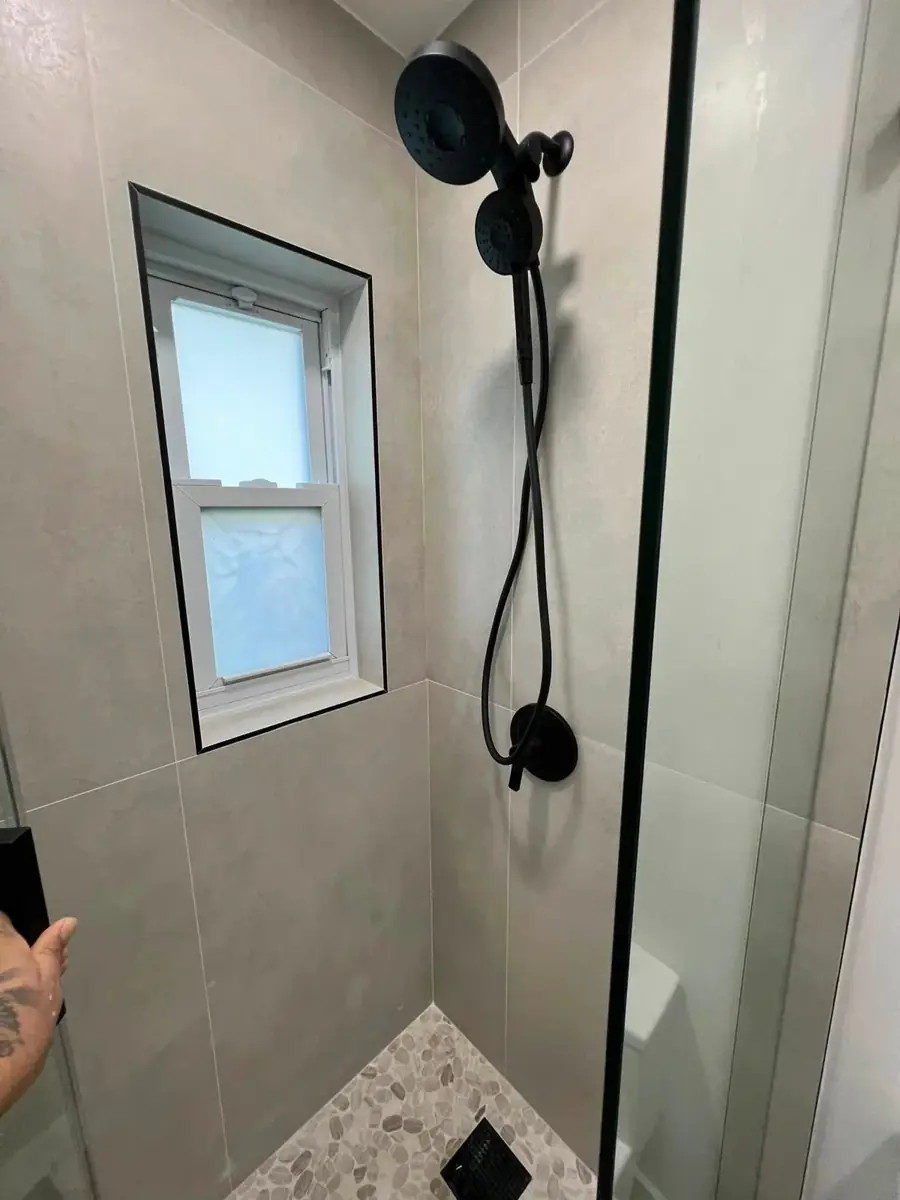 Ducha terminada con revestimientos y grifería negra