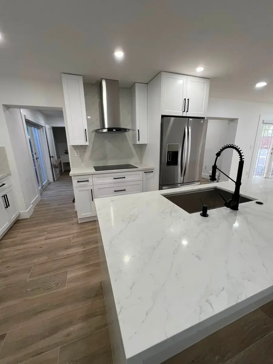 Cocina terminada con isla y gabinetes blancos